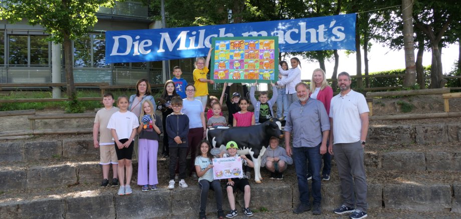 Fotounterschrift: Die Klasse 3b der Grundschule „Blaues Ländchen“ in Nastätten freute sich gemeinsam mit Stadtbürgermeister Marco Ludwig, Lehrerin Georgina Richter, Milag-Vertretungen Matthias Müller und Yvonne Riede sowie Schulleiterin Sabine Herwig (v.r.n.l.) über den Sieg beim Milag-Malwettbewerb. (Foto: Alexandra Nolden, Milag).