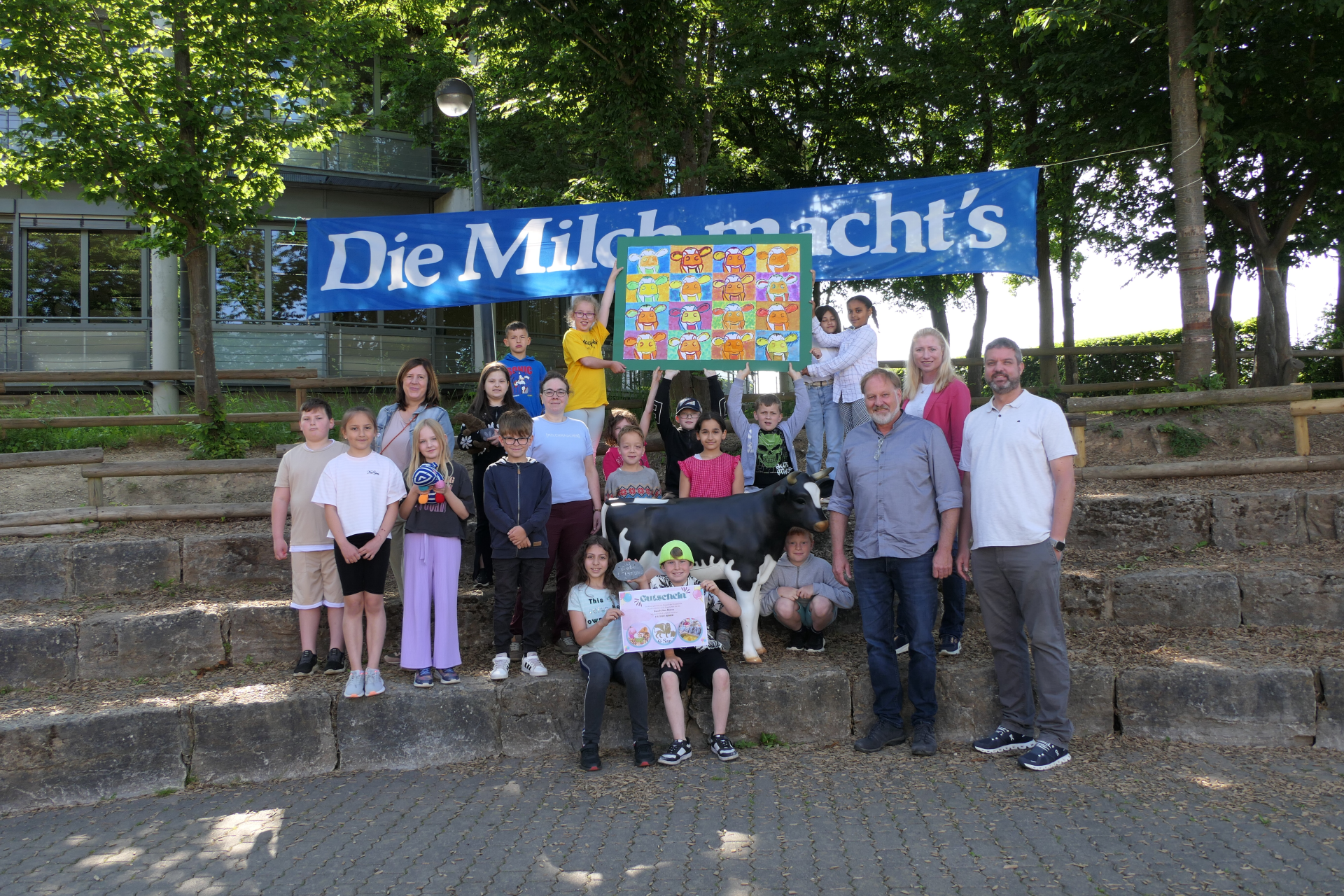 Fotounterschrift: Die Klasse 3b der Grundschule „Blaues Ländchen“ in Nastätten freute sich gemeinsam mit Stadtbürgermeister Marco Ludwig, Lehrerin Georgina Richter, Milag-Vertretungen Matthias Müller und Yvonne Riede sowie Schulleiterin Sabine Herwig (v.r.n.l.) über den Sieg beim Milag-Malwettbewerb. (Foto: Alexandra Nolden, Milag).